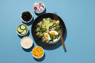 Mavi arka planda ton balıklı salata..