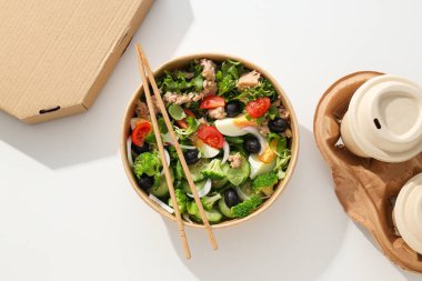 Işık masasındaki karton tabakta ton balığı salatası..