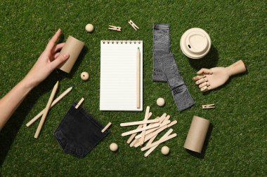 Yeşil arkaplan üzerinde yükseltme, el ve not defteri materyalleri, üst görünüm