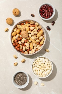 Fasulyeler, fındıklar ve chia tohumları hafif arka planda, üst manzara