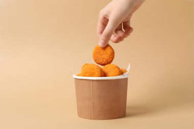 Bej arka planda karton bir kutuda kızarmış mozzarella.