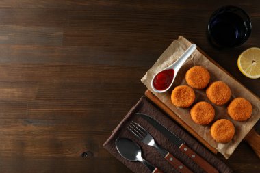 Kızarmış mozzarella soslu ve ahşap arka planda taze limon.