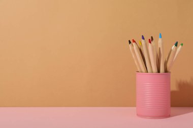 Bej arka planda pembe teneke kalemler, metin için boşluk