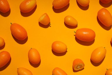 Turuncu arka planda kumkuat bütünlüğü ve parçalar, üst görünüm