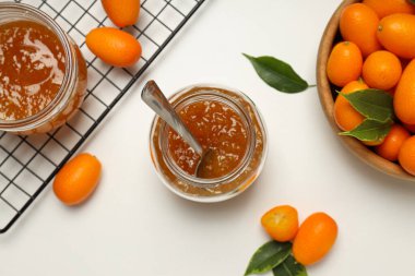 Kumkuat kasede ve kavanozlar dolusu reçel beyaz arka planda, üst manzara