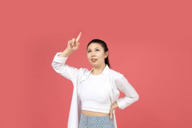 Asyalı bir kız pembe arka planda elini yana uzatıyor..