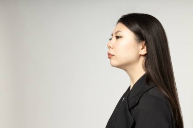 Katı, klasik takım elbiseli Asyalı bir kız..