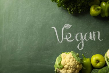 Yeşil arka planda protein sebzeleri ve Vegan kelimesi seti, metin için alan