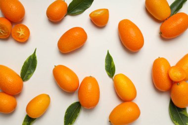 Kumkuat ve yapraklar beyaz arkaplanda, üst görünümde