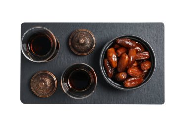 Kasede kurutulmuş hurma, Arbudu bardaklarında siyah çay, siyah tabakta bronz kase, üst manzara, beyaz arka planda izole edilmiş, PNG