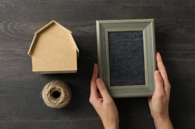 İp, el yapımı ev ve ahşap arka planda fotoğraf çerçevesi.