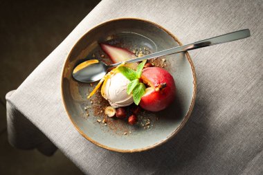 Dondurma ve armut şarapta tabakta ve kaşık arka planda, üst manzara