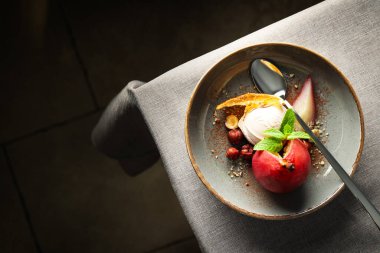 Dondurma ve armut şarap tabakta ve kaşık arka planda, mesaj için yer