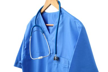 Askıdaki mavi önlük ve steteskop, beyazda izole edilmiş sağlık çalışanlarının kendilerini adamışlığını sembolize ediyor.