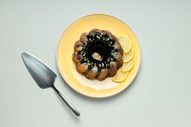 Limonlu kek ve dilimlenmiş limon gri arka planda, üst manzara