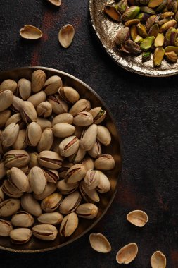 Koyu bir arka planda, tabakta fıstıklar..