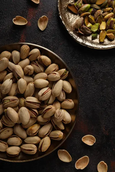 Koyu bir arka planda, tabakta fıstıklar..