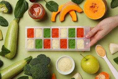 Yeşil arka planda çocuk sebzesi ve meyve püresi..