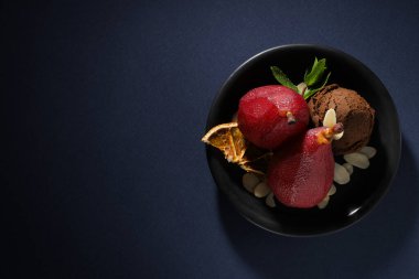 Dondurma ve armutlar tabakta koyu mavi zemin üzerinde, metin için yer var.