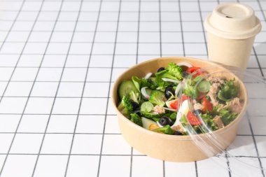 Işık masasındaki karton tabakta ton balığı salatası..