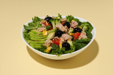 Sarı arka planda ton balıklı salata..
