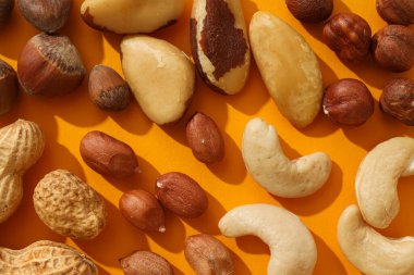 Turuncu arka planda değişik fındıklar var.