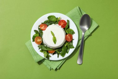 Yeşil arka planda domatesli bir kasede riotta.