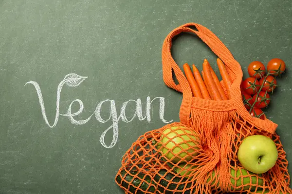 Poşette protein sebzeleri ve yeşil arka planda vegan sözcükler.