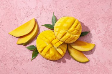 Pembe arka planda taze kesilmiş mango.