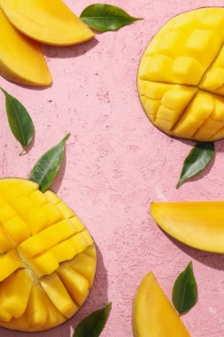 Pembe arka planda taze kesilmiş mango.