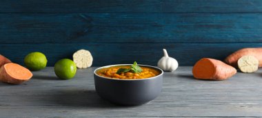 Tatlı patates püresi kasede ve ahşap arka planda malzemeler