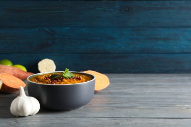 Tatlı patates püresi kasede ve ahşap arka planda malzemeler, metin için yer var.