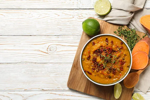 Tatlı patates püresi kasede ve mutfak tahtasındaki malzemeler ahşap arka planda, mesaj için yer var.