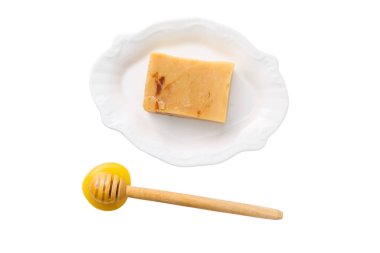 Bal ve tatlı bir tabakta sergilenir, beyazda izole edilmiş.