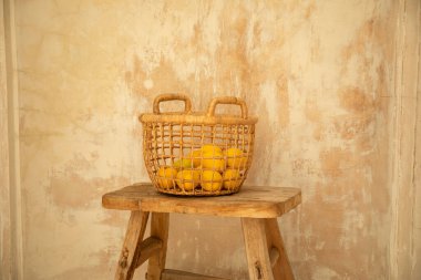 Dokuma sepetinde taze sarı limonlar var.