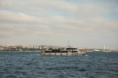 İstanbul ufkuyla birlikte su üzerinde seyreden bir tekne.