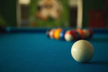 Bir oyuncu düzenli bir bilardo masasında kırmaya hazırlanıyor.