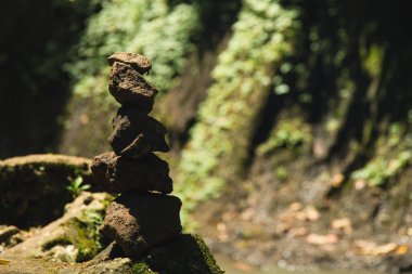 Taşlar sakin bir akıntıyla dengelenir, yeşillikle yemyeşil olur.