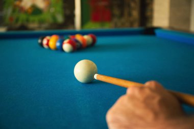Bir oyuncu yerel bir mekanda bilardo oynamaya hazırlanıyor.