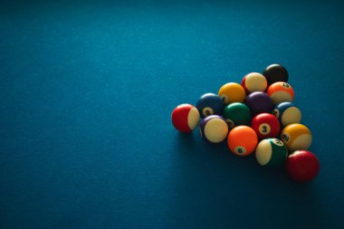 Bilardo topları mavi keçeli masada oynanacak bir oyun için düzenlenir.