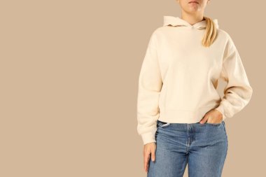 Bej kapüşonlu manken ve tarafsız arka planda kot pantolon