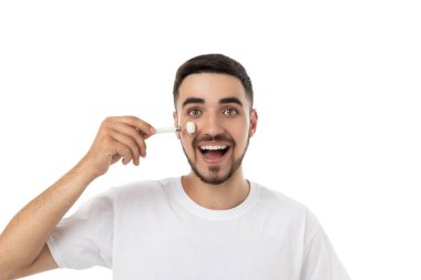 Adam mutlu bir şekilde cildine yüz silindiri sürüyor, izole edilmiş, PNG.