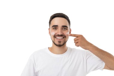 Genç adam yüzüne nemlendirici sürüyor mutlu, izole, PNG