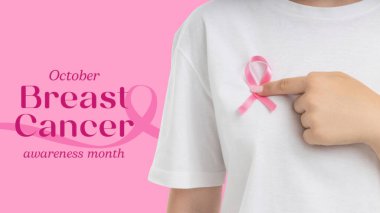 İnsan gömleğindeki pembe kurdeleyi göstererek farkındalığı arttırır.