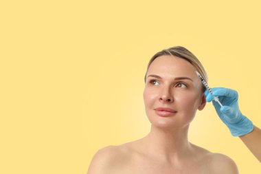 Kadın model klinikte kozmetik enjeksiyon yaptırıyor.