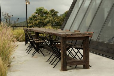 A group gathers at a rustic rooftop table with views