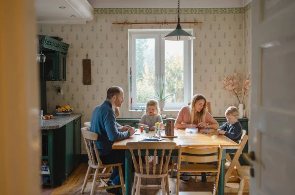 Happy young family at dining table at home together