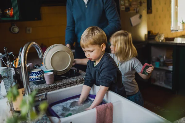 孩子们在厨房帮爸爸洗碗 — 图库照片