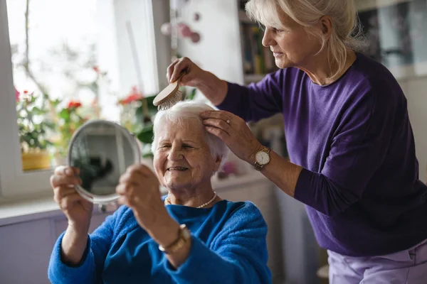 Женщина Расчесывает Волосы Пожилой Матери — стоковое фото