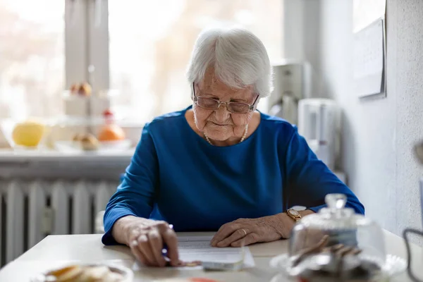 Senior Woman Filling Out Financial Statements — Stock Photo, Image